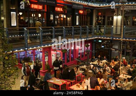 Londra, Regno Unito, 7 novembre 2021: A Kingly Court, appena fuori da Carnaby Street di Londra, nel cuore del West End, gli amanti dello shopping e i turisti possono fermarsi per mangiare al tramonto. Nonostante il freddo autunnale molte persone preferiscono ancora mangiare all'aperto, in quanto la buona ventilazione ha ridotto il rischio di trasmissione del coronavirus. Anna Watson/Alamy Live News Foto Stock