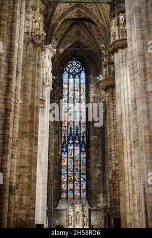 Vetrata colorata contro le colonne e soffitto ad arco nel Duomo. Italia, Milano Foto Stock