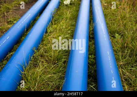 Tubi dell'acqua blu. I tubi industriali si trovano a terra. Dettagli di posa tubi con gas. Riparazione fognaria. Foto Stock