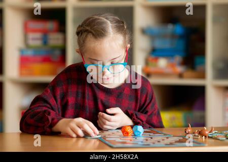 Ragazza con sindrome di Down gioca Giochi da tavolo in quarantena a casa Foto Stock
