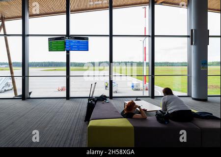 13/09/2021. Aeroporto Olsztyn-Mazury, Polonia. Alcuni passeggeri dopo il check-in seduti e in attesa del loro volo in aeroporto. Foto Stock