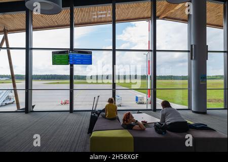 13/09/2021. Aeroporto Olsztyn-Mazury, Polonia. Alcuni passeggeri dopo il check-in seduti e in attesa del loro volo in aeroporto. Foto Stock