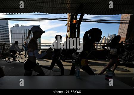 New York, Stati Uniti. 7 novembre 2021. Una atleta di alto livello raggiunge per il suo bootle d'acqua da un tavolo allestito al punto di 25 km. Sul 59th Street bridge mentre corre nella 2021 TCS New York City Marathon sulla sua 50th running a New York, NY, 7 novembre 2021. (Foto di Anthony Behar/Sipa USA) Credit: Sipa USA/Alamy Live News Foto Stock