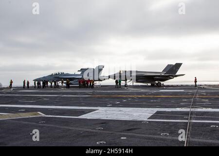 OCEANO PACIFICO (Nov. 5, 2021) un F-35C Lightning II, assegnato al Marine Fighter Attack Squadron (VMFA) 314, è incatenato al mazzo accanto ad un EA-18G Growler assegnato al Electronic Attack Squadron (VAQ) 133. Abraham Lincoln sta conducendo le operazioni di routine nella terza flotta degli Stati Uniti. (STATI UNITI Foto del corpo marino di 1° Ora. Charles Allen/rilasciato) Foto Stock