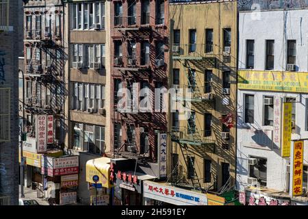 East Broadway, Chinatown, New York City, USA. Settembre 26, 2021. Trafficata strada commerciale principale a chinatown. Edifici residenziali con negozi in groun Foto Stock