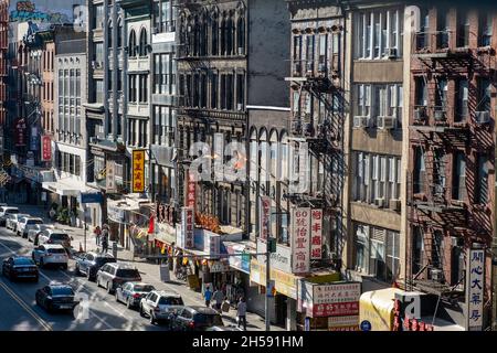 East Broadway, Chinatown, New York City, USA. Settembre 26, 2021. Trafficata strada commerciale principale a chinatown. Edifici residenziali con negozi in groun Foto Stock