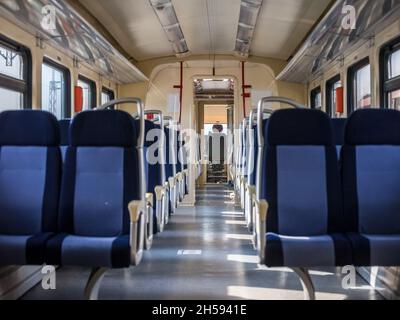 Immagine di un tipico sedile di un treno europeo, vuoto, lungo il tragitto in una campagna tipica dell'Europa, in un moderno treno regionale DMU. Foto Stock