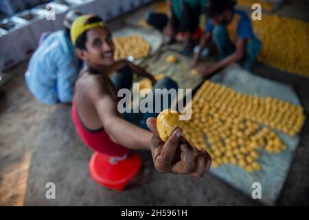 Roorkee, India. 6 novembre 2021. I lavoratori preparano le palle rotonde del jaggery per la vendita ad un'unità stagionale di produzione del jaggery nella parte più bassa di Roorkee.jaggery che fa da spremuta della canna da zucchero è un'industria rurale tradizionale in molte parti dell'India. Più del 70% della produzione mondiale di jaggery è fatta dall'India. Credit: SOPA Images Limited/Alamy Live News Foto Stock