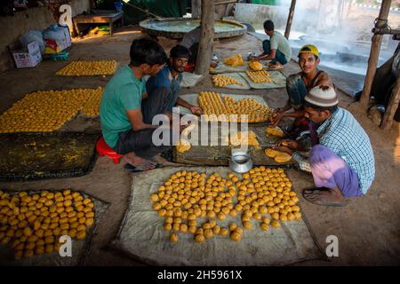 Roorkee, India. 6 novembre 2021. I lavoratori preparano le palle rotonde del jaggery per la vendita ad un'unità stagionale di produzione del jaggery nella parte più bassa di Roorkee.jaggery che fa da spremuta della canna da zucchero è un'industria rurale tradizionale in molte parti dell'India. Più del 70% della produzione mondiale di jaggery è fatta dall'India. Credit: SOPA Images Limited/Alamy Live News Foto Stock