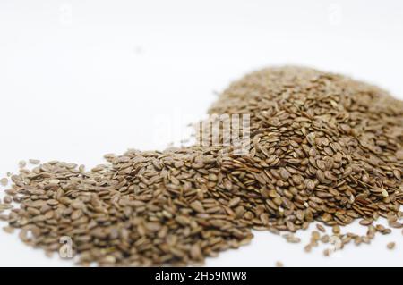 Primo piano orizzontale di semi di lino marroni su sfondo bianco Foto Stock