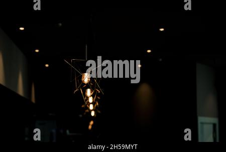 Caffetteria decorata con lampade minimaliste in un moderno stile loft. Spia di colore giallo. Foto Stock