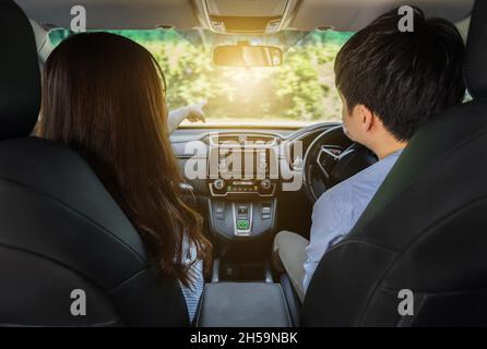 giovane coppia seduta e guida in auto Foto Stock