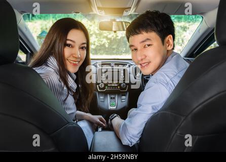felice giovane coppia seduta in macchina Foto Stock