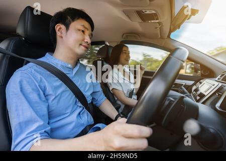 giovane coppia seduta e guida in auto Foto Stock