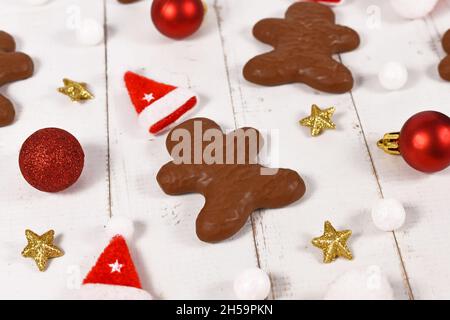 Pan di zenzero tedesco a forma di uomini smaltati con cioccolato tra le decorazioni di Natale Foto Stock