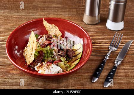 Insalata di diversi tipi di salsicce, cetrioli, peperoni, lattuga con panna acida salsa Foto Stock