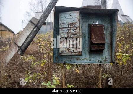 Cassette postali arrugginite in un vecchio villaggio russo abbandonato Foto Stock