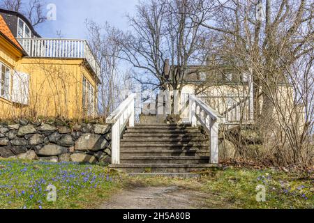 Stoccolma, Svezia - 6 aprile 2021: Vecchia casa svedese in legno con scale con recinzione bianca Foto Stock
