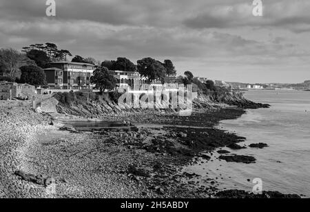 Foto monocromatica del bagno di Devil's Point sul lungomare di Stonehouse, Plymouth. La marea mostra la costa rocciosa coperta di alghe marine. Foto Stock