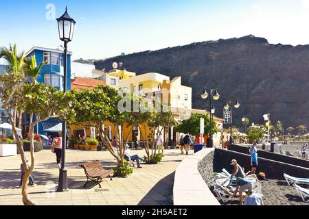 Puerto de Tazacorte, la Palma, Isole Canarie - 8 dicembre 2019: Turisti sul lungomare e la spiaggia, bevo l'eruzione del vulcano. Foto Stock