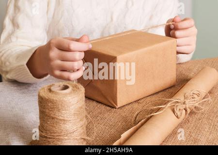 Confezione donna. Carta da imballaggio Kraft e spago naturale. Riciclaggio del materiale. Felice vacanza presente, sorpresa. Regali per il giorno di boxe. Servizio di consegna Foto Stock