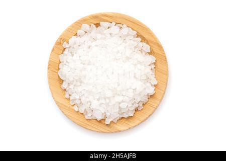 Piatto di legno con grani di sale marino isolato su bianco, vista dall'alto Foto Stock
