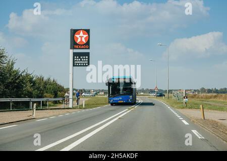 Strada autostradale olandese con autobus 28 e distributore di benzina Texaco pilastro pubblicità Foto Stock