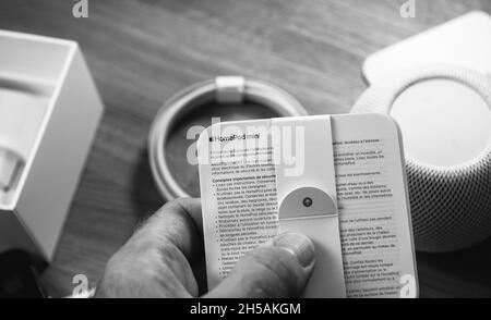 Uomo che sboxe l'ultimo Apple Computers HomePod Mini altoparlante intelligente Foto Stock