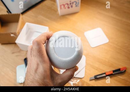 Uomo che sboxe l'ultimo Apple Computers HomePod Mini altoparlante intelligente Foto Stock