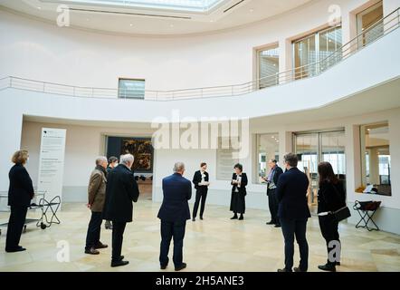 Berlino, Germania. 8 novembre 2021. I membri del Kaiser Friedrich Museumsverein, così come gli iniziatori della lapide commemorativa, si trovano nella rotonda nel Gemäldegalerie di fronte alla lapide, che è stata annegata nel muro dal dicembre 2020. La targa, in pietra naturale grigio chiaro, commemora i membri sradicati dell'associazione e si trova a destra della porta d'ingresso. Credit: Annette Riedl/dpa/Alamy Live News Foto Stock