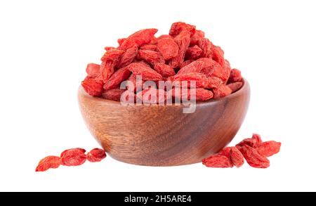 Frutti di bosco cinesi in ciotola di legno, isolati su sfondo bianco. Mucchio di bacca di goji secca. Foto Stock