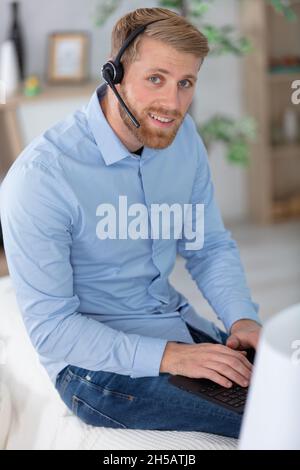 uomo seduto in soggiorno a casa con cuffia Foto Stock
