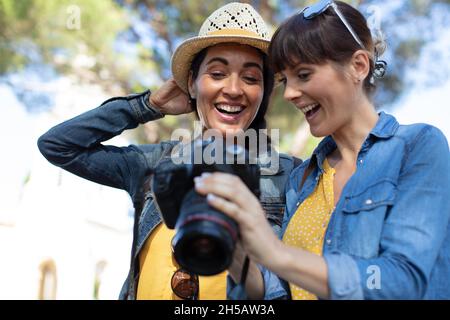 Giovane donna che mostra le foto al suo amico Foto Stock