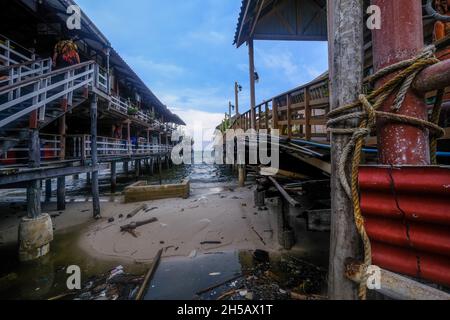 Vecchi moli di legno sporgono fuori nel mare a Hua Hin, Tailandia Foto Stock