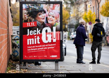 Colonia, Germania. 8 novembre 2021. Un poster con l'iscrizione '11.11. Jeck mit G!" si trova a una fermata dell'autobus. A causa dei numeri crescenti di Corona, la città di Colonia vuole inasprire le regole per il lancio del carnevale del 11.11. Ancora una volta. Nelle zone del centro storico e nel quartiere Zülpicher, 3Gplus non sarà più applicabile il giovedì, ma 2G. Anche in tutti gli eventi della sala e nei pub 2G dovrebbe essere obbligatorio. Credit: Rolf Vennenbernd/dpa/Alamy Live News Foto Stock