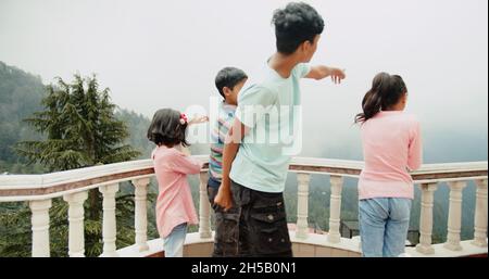 Quattro piccoli fratelli indiani che si divertono sul balcone a Shimla, Himachal Pradesh, India Foto Stock