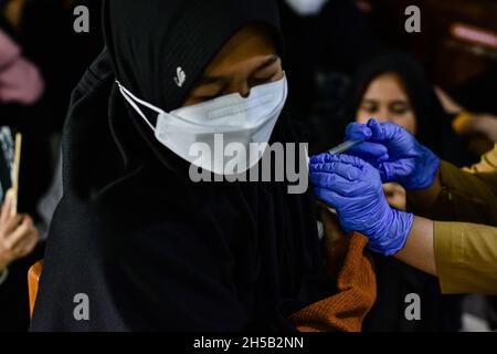 Soppeng, Indonesia. 8 novembre 2021. Uno studente di un collegio riceve la prima dose di vaccino COVID-19 Sinovac in una delle scuole di imbarco islamiche nel distretto di Soppeng. Un totale di 260 studenti hanno ricevuto il vaccino Sinovac COVID-19. Il governo indonesiano sta intensificando il programma di vaccinazione per gli studenti per sostenere l'attuazione di un apprendimento faccia a faccia (PTM) limitato nelle regioni. (Foto di Moch Farabi Wardana/Pacific Press) Credit: Pacific Press Media Production Corp./Alamy Live News Foto Stock