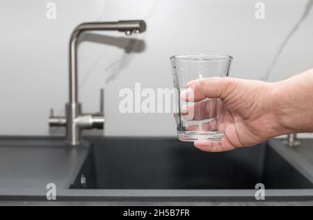 Uomo pronto a versare acqua filtrata in vetro Foto Stock