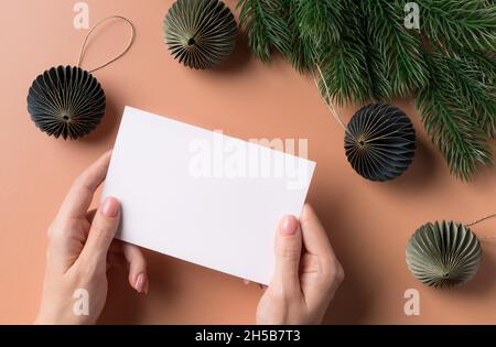 Scena mockup biglietto d'auguri con le mani femminili che reggono carta carta vuota Foto Stock