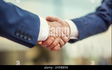 Due mani tremanti di uomini d'affari dopo un incontro di successo. Foto Stock