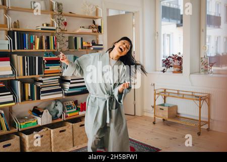 Una donna allegra che ama ballare a casa Foto Stock