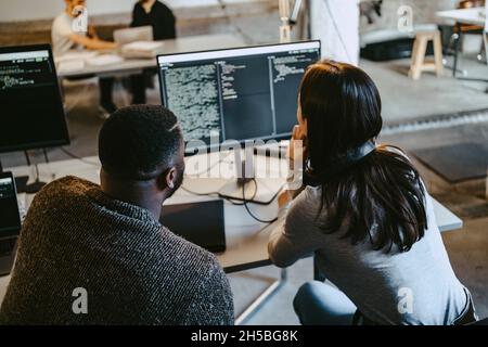 Programmatori maschi e femmine che codificano su computer in ufficio creativo Foto Stock