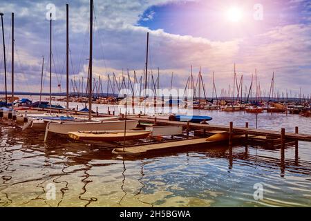 Piccole barche a vela private e yacht si stendere scompattati sul molo del lago al sole Foto Stock