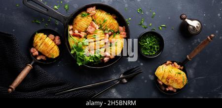 Patate al forno con prosciutto, erbe e pangrattato su sfondo scuro. Cucina scandinava. Vista dall'alto. Foto Stock