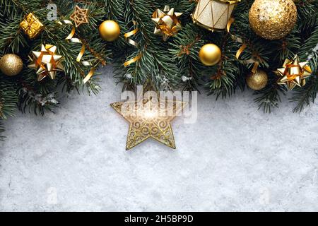 Concetto di sfondo di Natale, vista dall'alto. Rami di abete rosso con decorazioni di Capodanno e una stella di Natale su sfondo di neve. Foto Stock