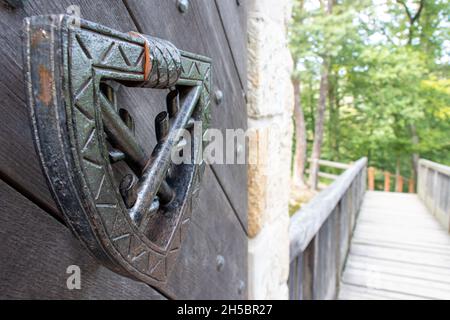 Il bussatore di ferro con lo stemma di famiglia di un antico clan aristocratico sulla porta del castello. Foto Stock