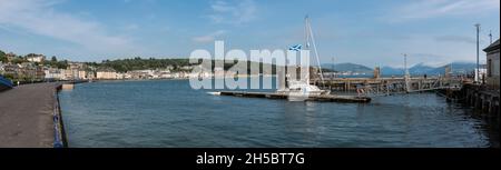 Spianata Rothesay con case fronte mare, acqua aperta, porto e penisola di Cowal sullo sfondo sotto cielo blu e nuvola chiara. Foto Stock