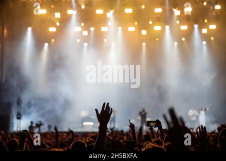 sagome di una folla di concerti di fronte alle luci del palco Foto Stock