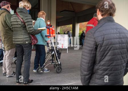 08 novembre 2021, Baden-Wuerttemberg, Biberach an der Riß: Una linea di persone si trova fuori dal centro di vaccinazione del municipio. Dopo che la contea ha le incidenze più alte a livello nazionale, un centro di vaccinazione è stato istituito nel municipio. Foto: Stefan Puchner/dpa Foto Stock