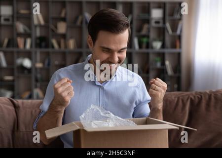 Felice giovane uomo che si sente eccitato di ottenere oggetto desiderato. Foto Stock